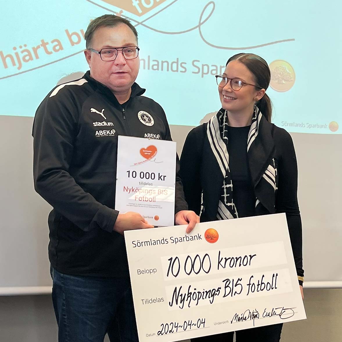 Emelie Kåbring från banken delar ut sparbankshjärtat till Nyköpings BIS fotboll