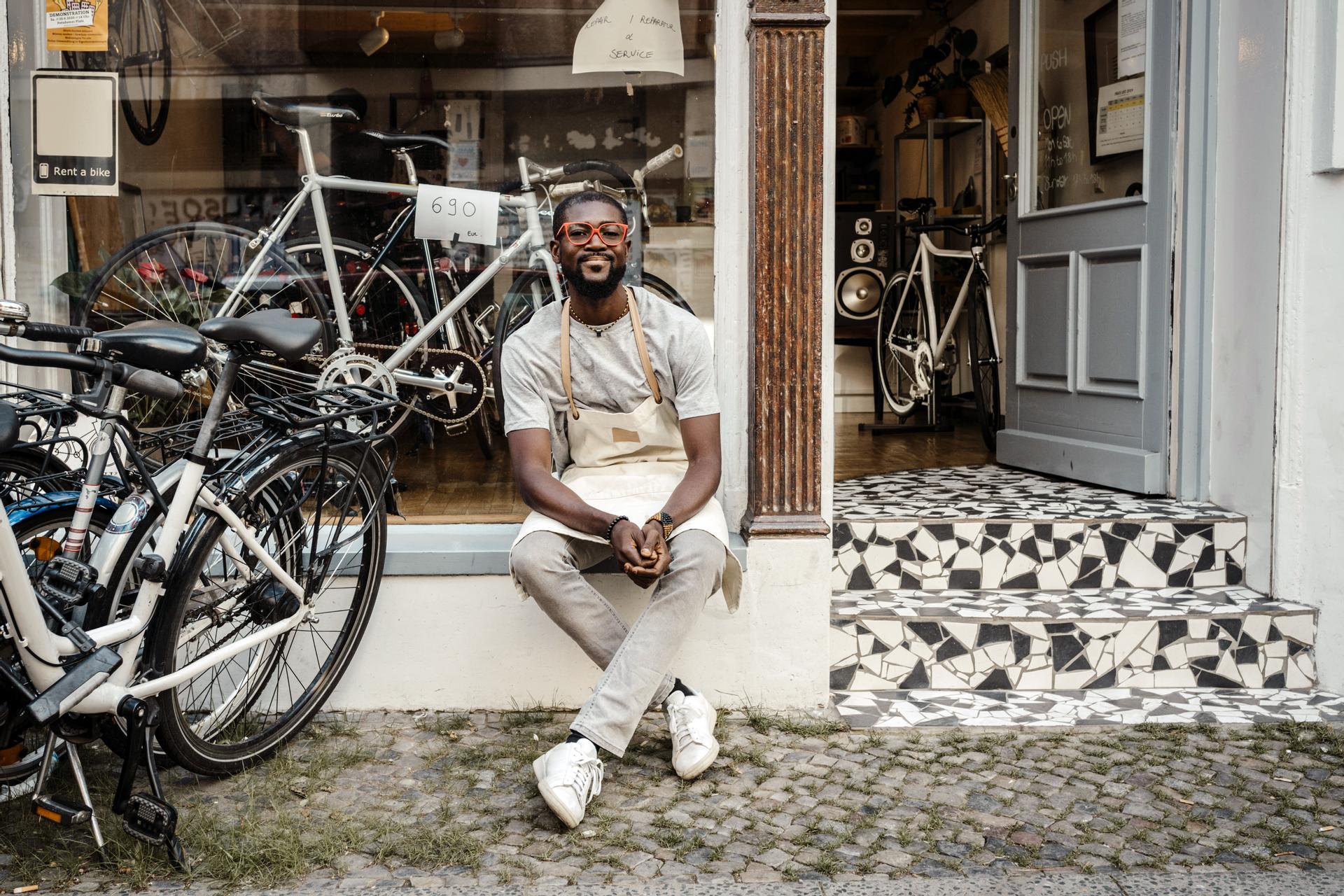 Företagsägare sitter utanför sin cykelaffär