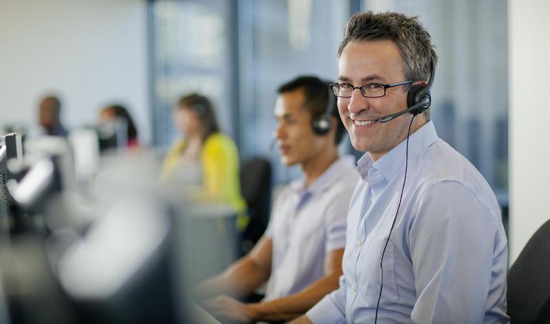 Smiling man with headset at customer center