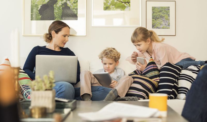 Mother with two children looking at differnet devices